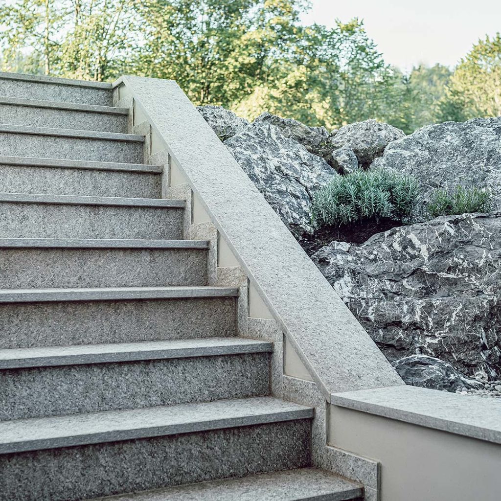 Lichtgraben und Außentreppe mit Natursteinplatten